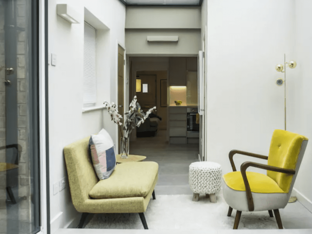 Minimalist cottage seating area with yellow armchairs and natural light — rustic home inspiration.