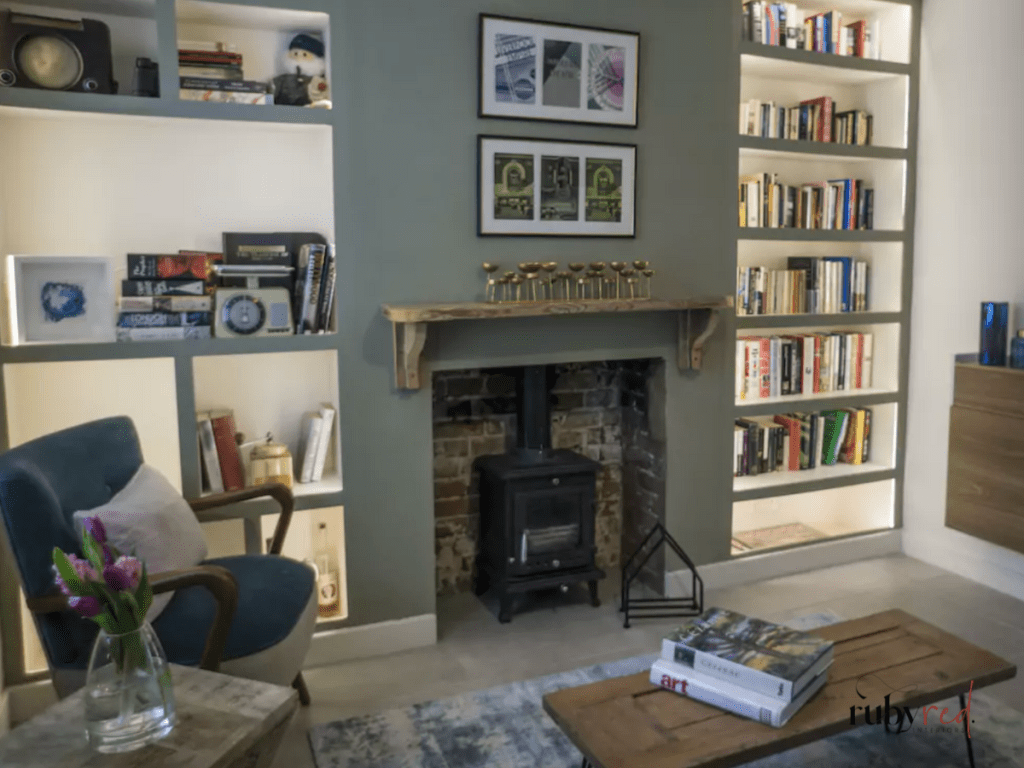 Rustic farmhouse living room with wood-burning stove, built-in bookcases, reclaimed wood coffee table, and cottage-style decor.